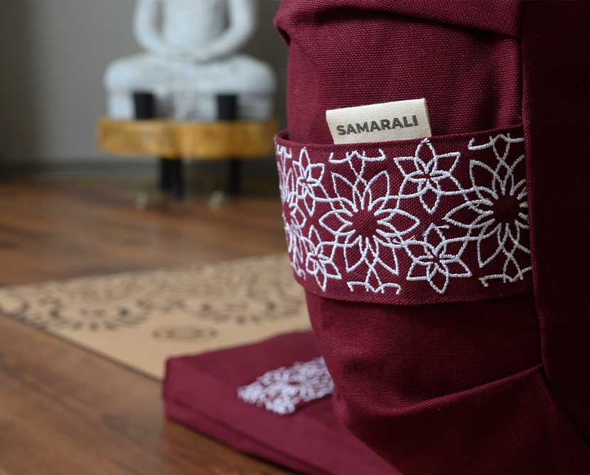 A beautifully embroidered mediation cushion in maroon color 
